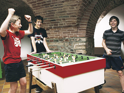 Kinder spielen am Kickerkasten